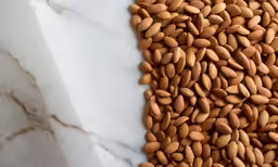 almonds sit in a white marble bowl on top of a counter