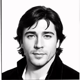 a man wearing a black jacket and staring at the camera