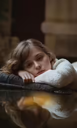 a girl posing on a floor with her hands behind her head