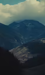 mountains are pictured in the distance on a cloudy day
