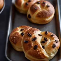 rolls are arranged on a baking pan with chocolate chips