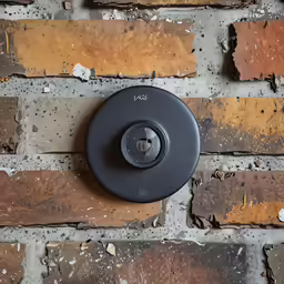 a black knob on a brick wall