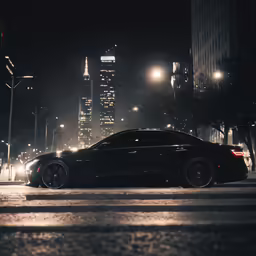 an all black bmw in a city at night