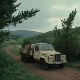 a truck driving down a dirt road in the mountains