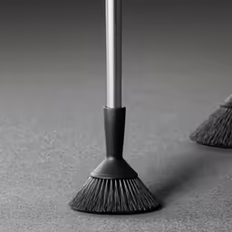 a dust brush leaning on a pole