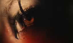 an eye with long eyelashes and brown eyes