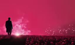 a man is standing alone in a field of flowers