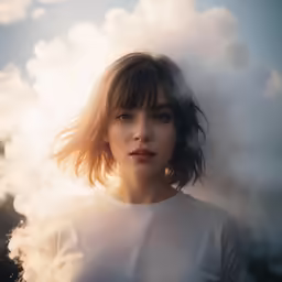 a beautiful woman standing next to clouds blowing