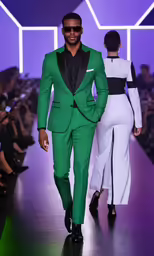 man in green suit walking down the runway