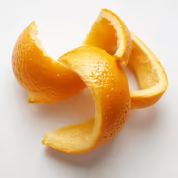 an orange peel sits on a white surface