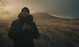 a person wearing a winter coat and holding a cell phone