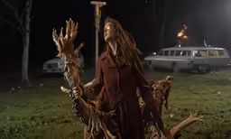 a woman in red outfit holding some fake things