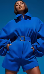 the woman in the blue suit is posing for a photo