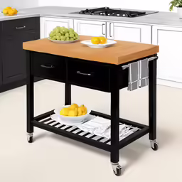 two bowls of fruit on a butcher block on a kitchen island
