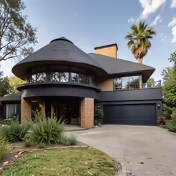 a black round home sitting in the middle of a lush green field