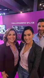two men and one woman are standing in front of a sign