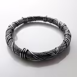two wire bracelets with silver beads are sitting on the table