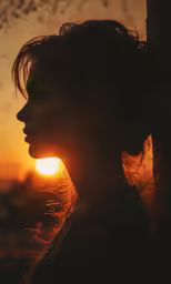 woman with dark hair at sundown looking out over city