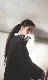 a girl with long hair walking through a doorway