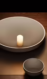 a lit candle sits on the edge of a serving tray