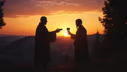 two people stand on top of a mountain