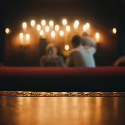 blurry photograph of two people sitting by candles