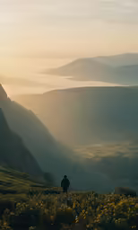 a lone hiker on a hilltop enjoying the sunset in the mountains