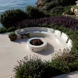 a firepit with flowers on the edge next to a path