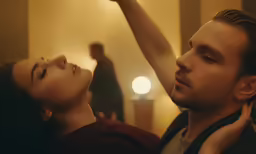a man standing next to a woman putting her hands together