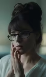 woman with glasses staring into the camera