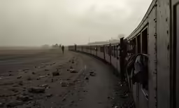 a lone person walking beside the side of the train