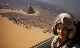woman wearing a helmet sitting in the cockpit of a plane