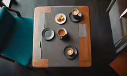 a square shaped wooden table topped with dishes