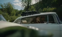 a woman in a car with her back to the camera