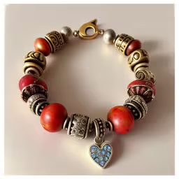 a bracelet with colorful beads and silver charms,a bracelet that has two different charms attached to it