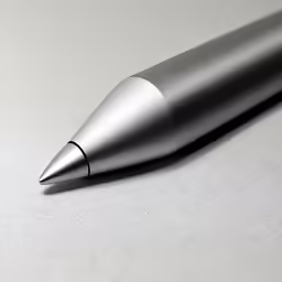 a close up of a metallic pen on a grey surface
