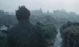 a man in the middle of a rain - soaked field