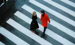 two people walking across a crosswalk in the snow