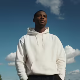 a man is standing against a blue sky