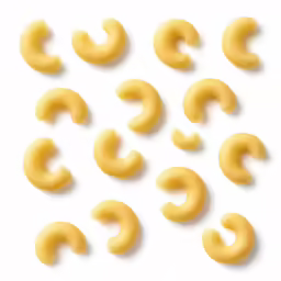 several pairs of uncooked yellow dough with small cursive shapes