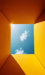 a bright blue sky is seen from inside a square structure