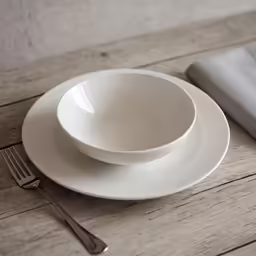 white plates and silverware are setting on a table
