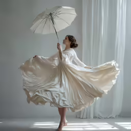 a woman in a long white dress holding an umbrella