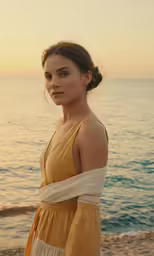 a young woman standing on a beach next to the ocean