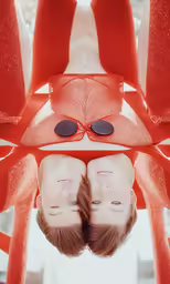 two young women are standing together with large orange objects around them