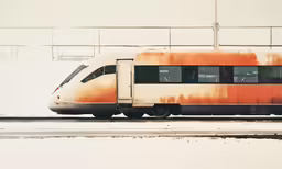 a white and orange train traveling along a track