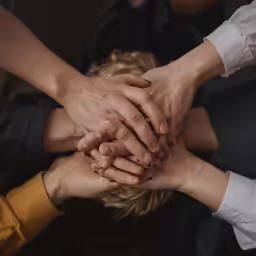 six hands together, each with one being held in the air