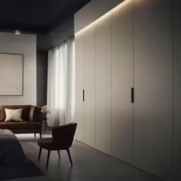 a bedroom with large sliding doors, a large couch and a chair