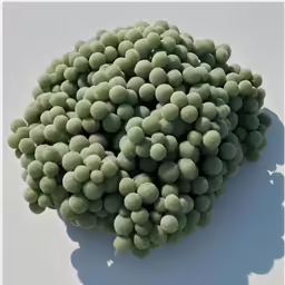 several small green balls of green algae floating in the air