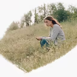 woman sitting in grass looking down